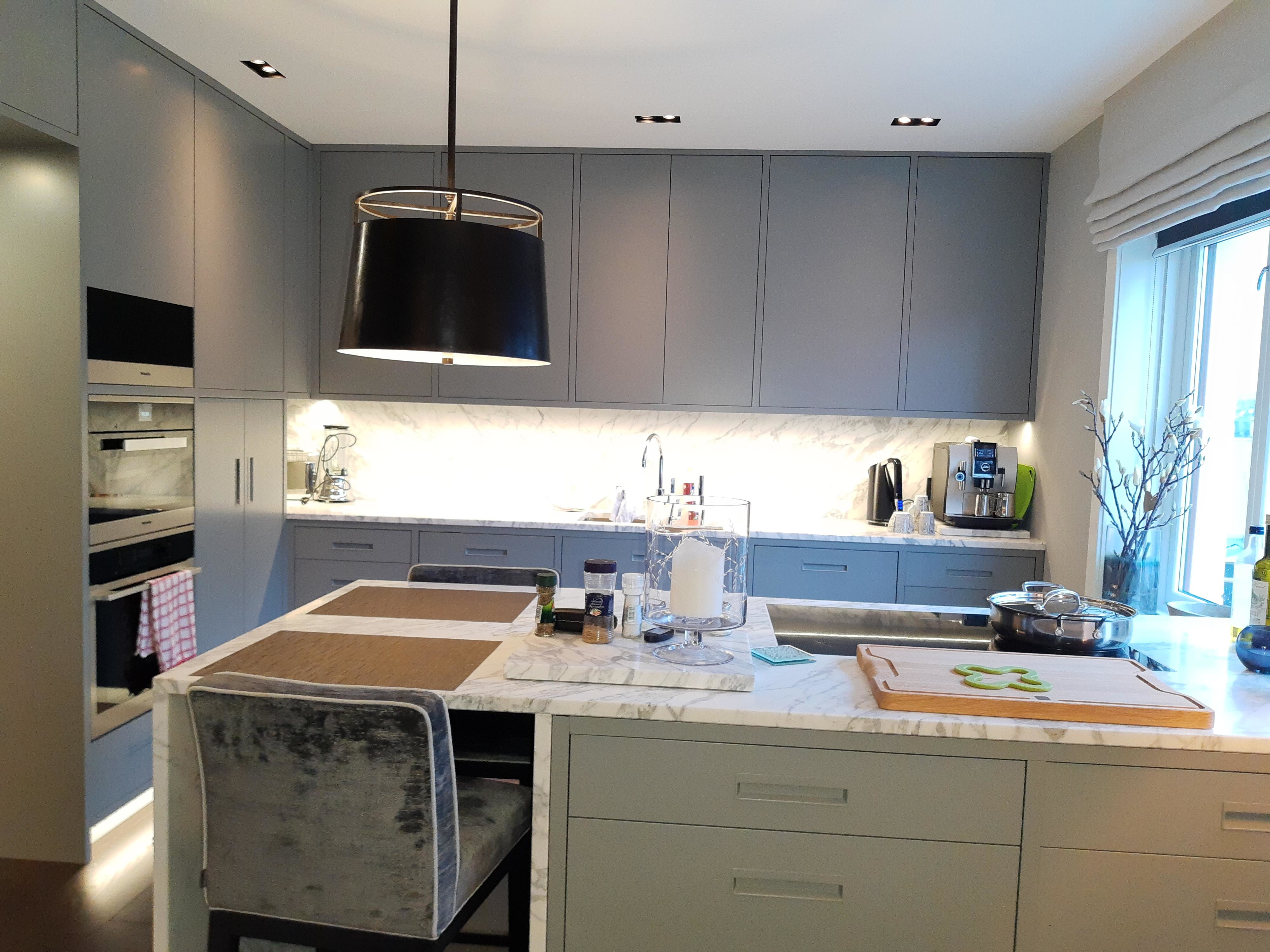 Custom fitted kitchen with grey cabinets and marble worktops