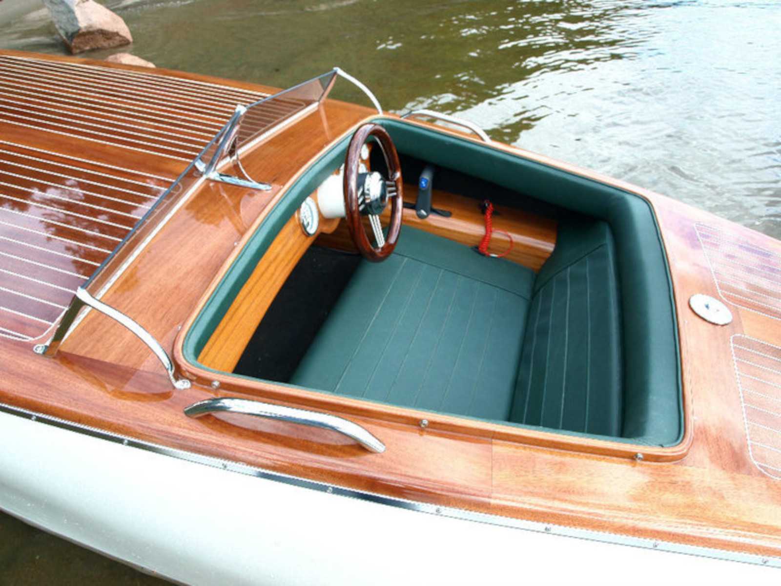 Restored classic wooden speedboat on the water with high-gloss deck